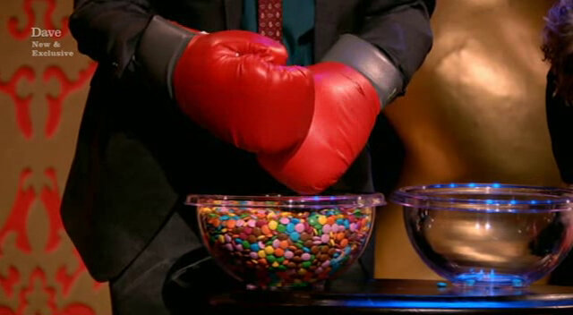 Image showing Frank Skinner painstakingly manipulating Smarties with his boxing gloves.